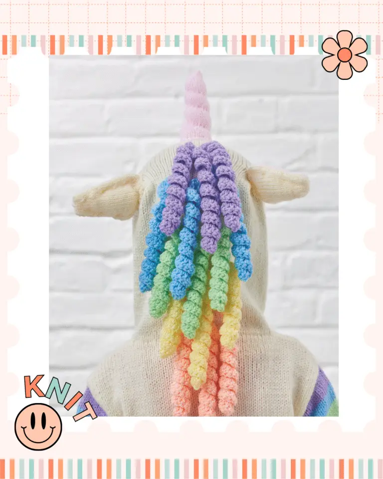 the back view of a childs hooded sweater, the sweater is unicorn themed and the picture shows the unicorn ears, pink horn and rainbow coloured spiral mane running down the back of the hood. knitting pattern by jane burns